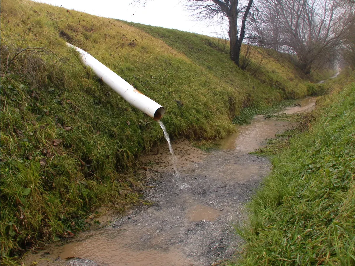 Discharge pipe outlet running into a roadside drainage ditch in rural Northeast Ohio